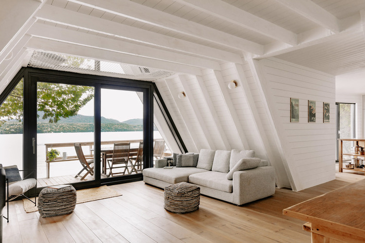 Enterijer moderne vikendice A-okvira ispunjen je prirodnom svetlošću i belom bojom